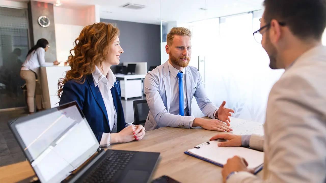 Business people sitting at a desk.